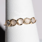 Side view of a moonstone ring with a rounded gold band