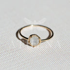 Moonstone solitaire and diamond accents on a yellow gold ring