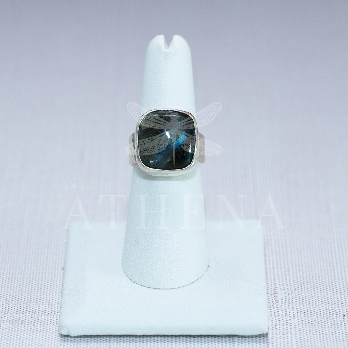 Side view of a wide hammered silver band with labradorite