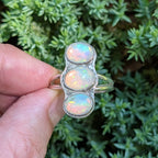 Close-up of three oval opals in handcrafted silver bezels