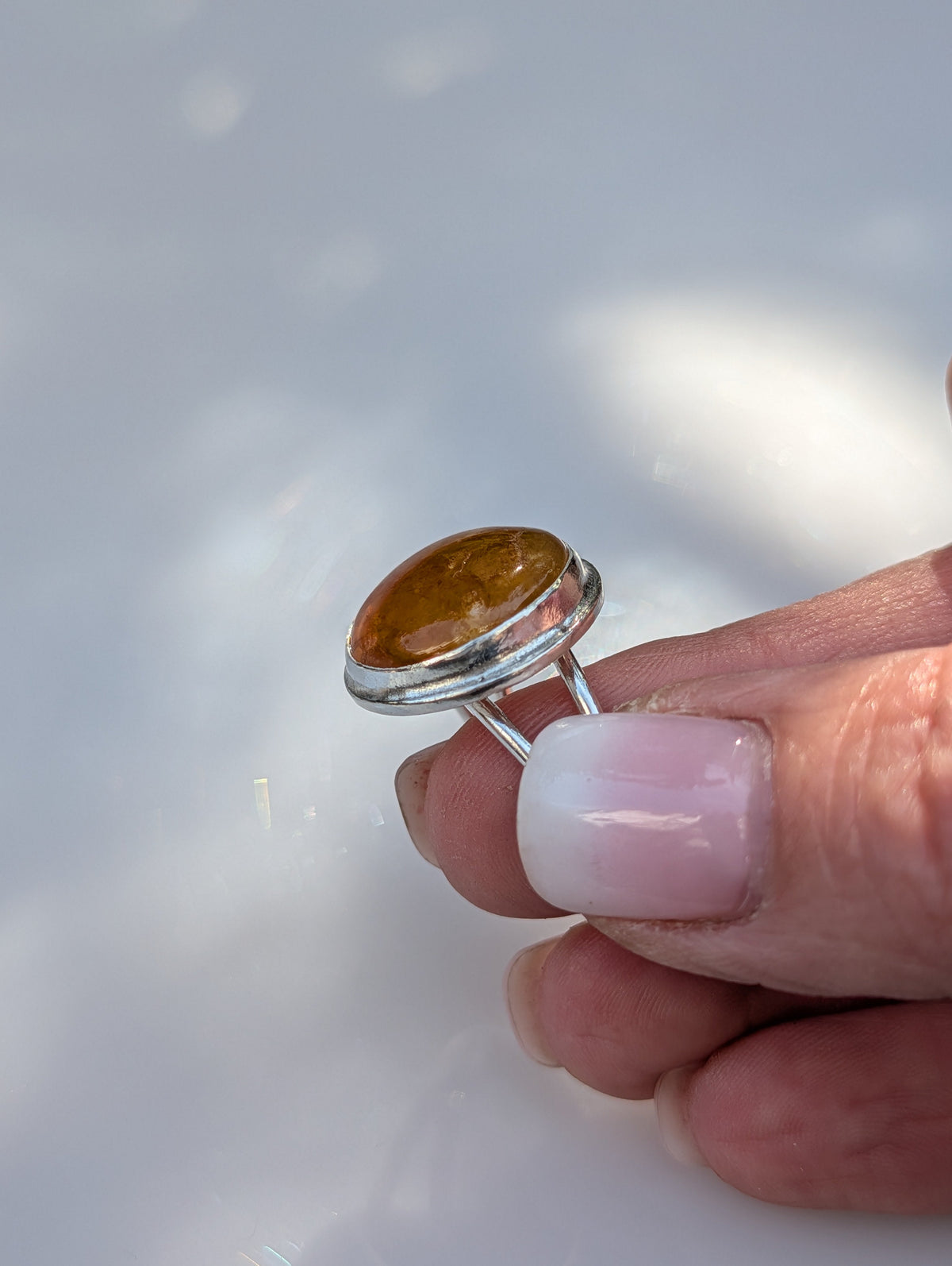 Hand-carved sterling silver ring with a golden gemstone