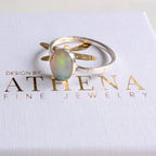 Fire opal ring with green flashes in a polished silver setting