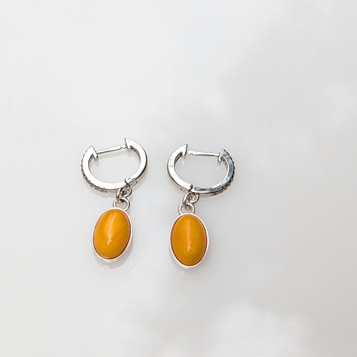 Oval butterscotch amber earrings with sterling silver hooks and bezels